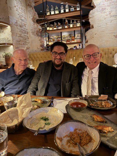 Bob Leaf at a restaurant table with two companions, plates of food between them.